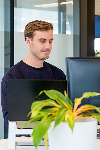 Vriendelijke collega werkt achter scherm aan customer journey optimalisatie